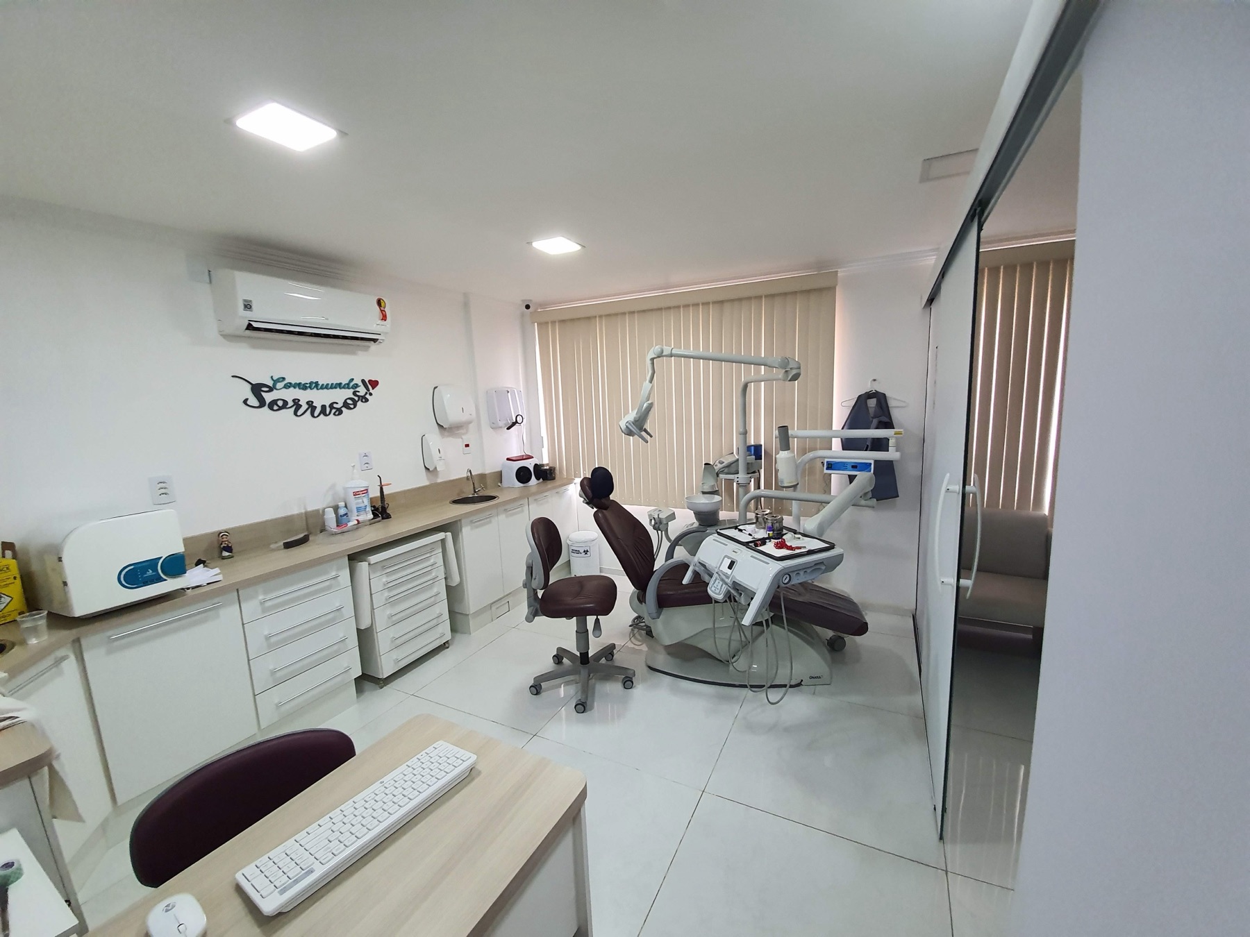Consultório amplo e organizado com cadeira odontológica